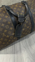 Louis Vuitton Keepall Bandoulière 55 in Monogram Macassar canvas with black leather trim